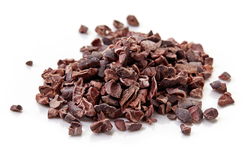 Heap of cacao nibs on white background